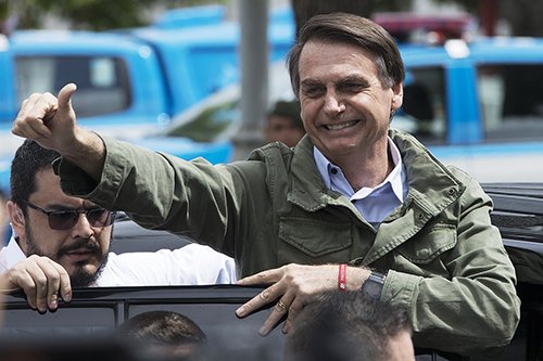 Presidential candidate Jair Bolsonaro, of the far-right Social Liberal Party, gives thumbs up to supporters after voting at a polling station in Rio de Janeiro, Brazil, Sunday, Oct. 28, 2018. Bolsonaro is running against leftist candidate Fernando Haddad of the Workers' Party. (AP Photo/Leo Correa)