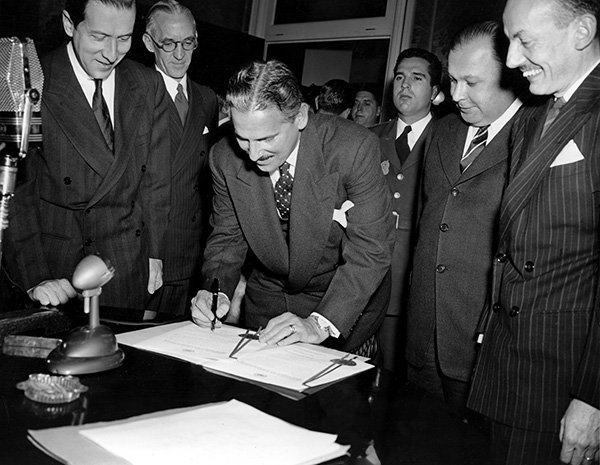 Kubas president Carlos Prio Socarras undertecknar dokumentet som upprättar OAS i den Panamerikanska unionens byggnad i Washington DC den 9 december 1948. Foto: AP/TT