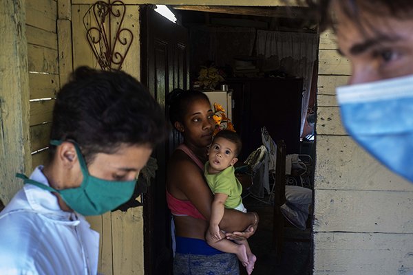Medicinstudenter besöker hem på den kubanska landsbygden för att kontrollera för corona-symptom. Foto: Ramon Espinosa/AP/TT