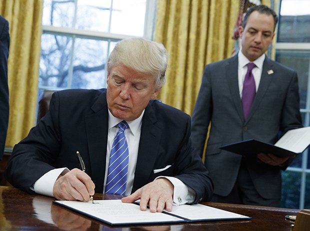 USA:s tidigare president Donald Trump under­tecknar en exektuiv order om att landet ska dra sig ut Stilla havspartnerskapet TPP den 23 januari 2017. Beslutet banade väg för RCEP-avtalets undertecknande. Foto: Evan Vucci/AP/TT.