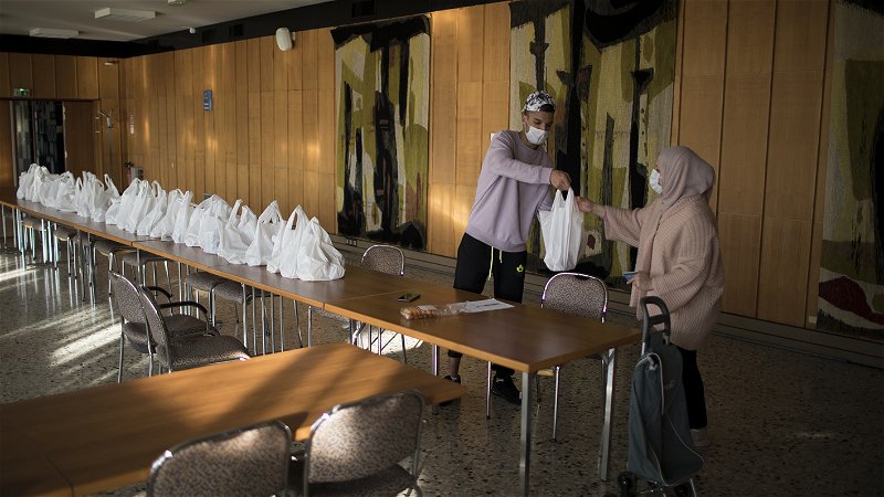 En välgörenhetsarbetare delar ut gratis mat till behövande vid en matbank i Marseille den 10 november 2020. Foto: Daniel Cole/AP.