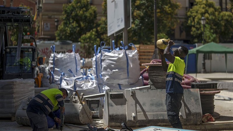 Arbetare dricker vatten i hettan vid en byggarbetsplats i Madrid den 10 juli. Foto: Manu Fernandez/AP.