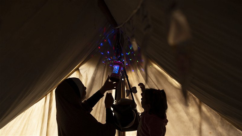 En familj dekorerar sitt tält inför Ramadan i Muwasi i södra Gaza den 11 mars. Foto: Fatima Shbair/AP.