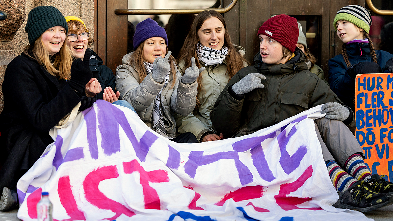 Greta Thunberg skojar med kamrater på andra sidan gatan. Foto: Christine Olsson/TT.