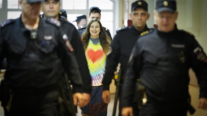 Konstnären Aleksandra Skotjilenko eskorteras till rättegången i Sankt Petersburg i november förra året 
för att ha bytt ut prislappar mot fredsbudskap. Foto: Dmitri Lovetsky/AP.