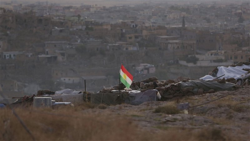 En kurdisk flagga hissad utanför Sinjar i norra Irak. Foto: Bram Janssen/AP.