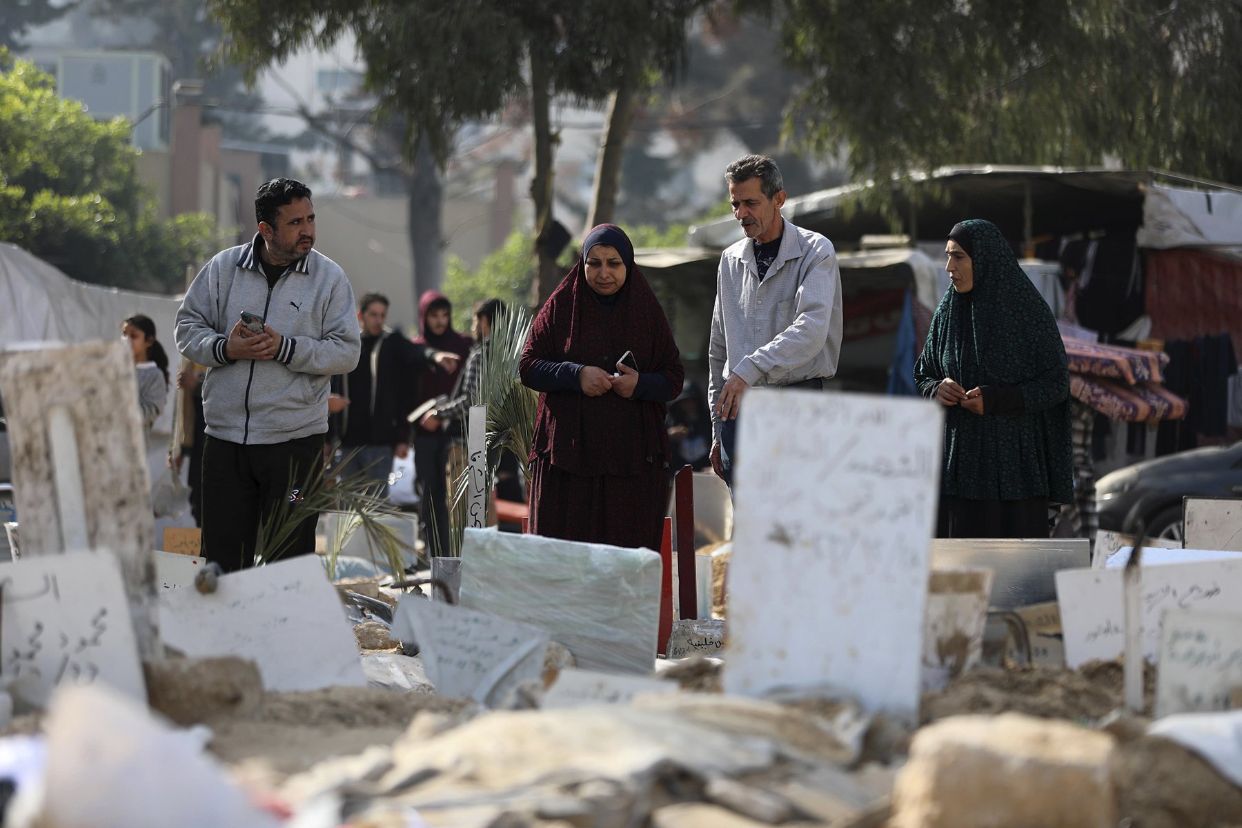 Palestinier sörjer vid gravar som rests för bomboffer och människor som hittats i jorden under sjukhuset al-Shifa i Gaza. Foto: Mohammed Hajjar/AP.