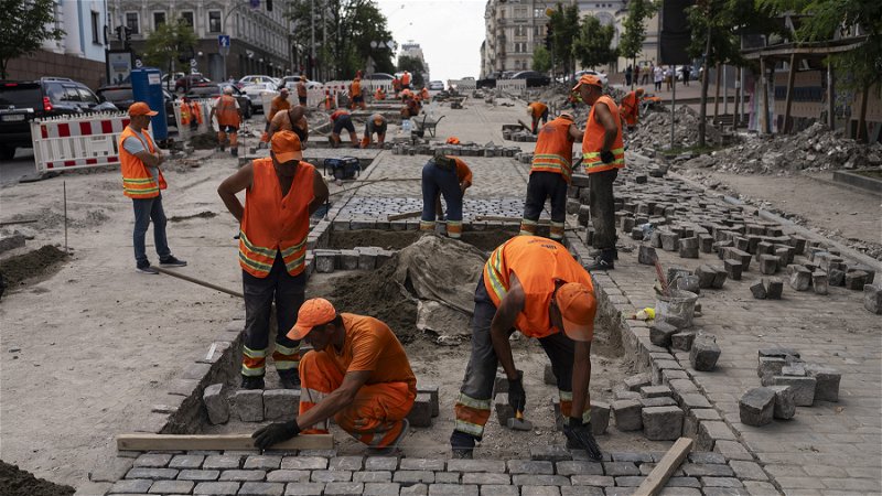 Arbetare lägger gatsten i Ukrainas huvudstad Kiev den 5 juli 2023. Foto: Jae C. Hong/AP.