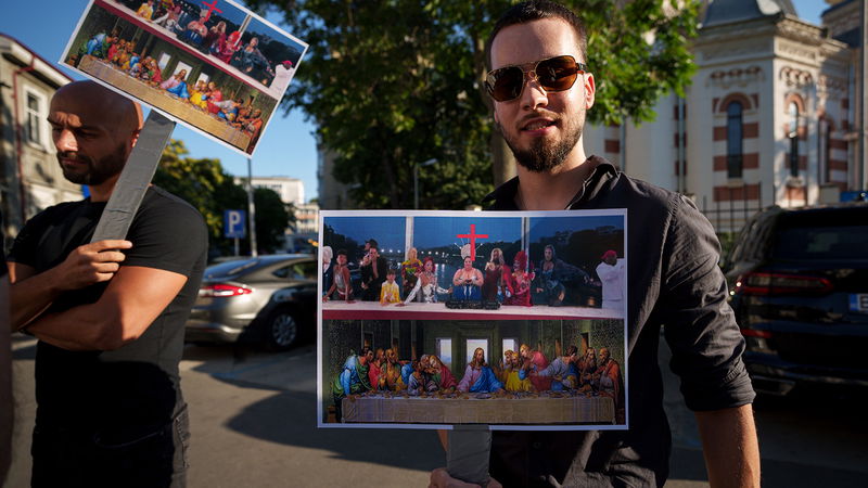 Två män protesterar mot OS-invigningen i Paris utanför Frankrikes ambassad i Bukarest, Rumänien. Foto: Andreea Alexandru/AP.