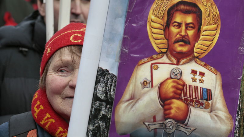 En kvinna hedrar diktatorn Josef Stalin under högtidlighållandet av Fosterlandsdagen den 23 februari 2023. Foto: Mikhail Metzel/AP.