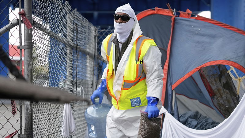 En anställd på myndigheten San Francisco Public Works tömmer ett läger för hemlösa i augusti 2024. Foto: Godofredo A. Vásquez/AP.