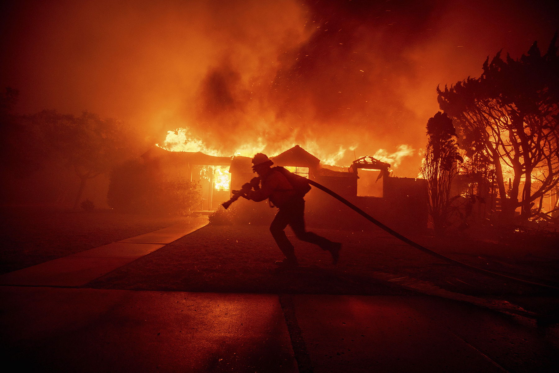 En brandman strider mot löpelden i grannskapet Pacific Palisades i Los Angeles, den 7 januari. Foto: Ethan Swope/AP/TT.