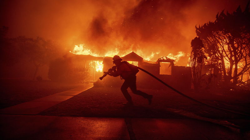 En brandman strider mot löpelden i grannskapet Pacific Palisades i Los Angeles, den 7 januari. Foto: Ethan Swope/AP/TT.