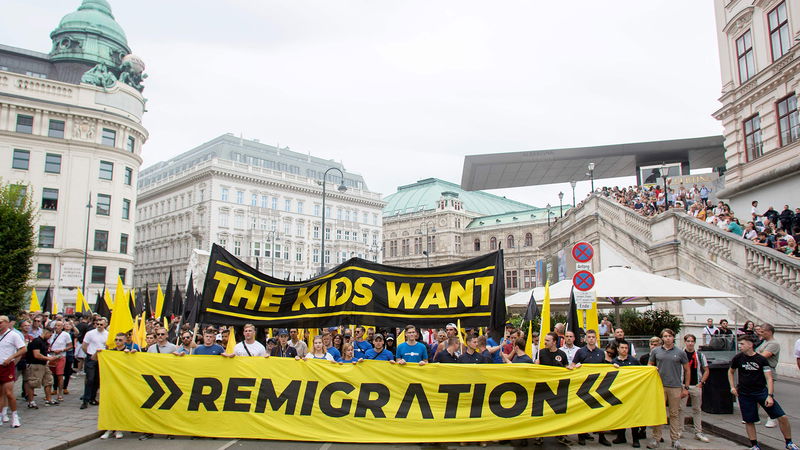 Den nyfascistiska identitära rörelsen håller upp plakat med budskapet ”Ungdomen vill ha återvandring” under en demonstration i Wien den 20 juli 2024. Foto: Alex Halada/AFP/TT.