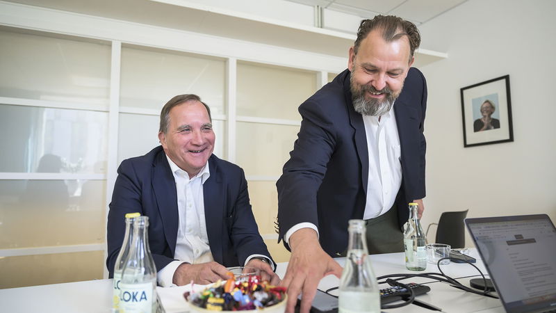 Stefan Löfven vänslas med Morten Rud Pedersen, vd på public affairs-bolaget Rud Pedersen. I bakgrunden hänger ett porträtt av tidigare socialdemokratiska utrikesministern Anna Lindh. Foto: Jesper Frisk/DI/TT.