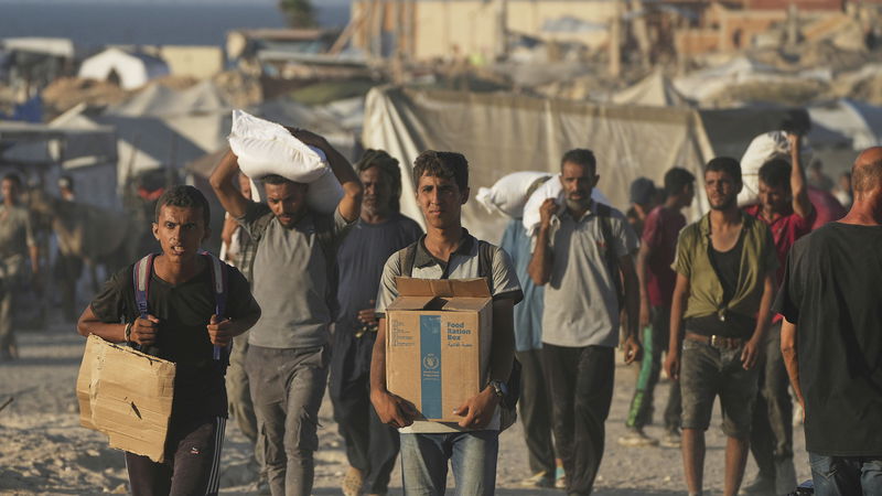 Palestinier i Gaza bär på sällsynta nödförsändelser från World Food Program. Foto: Abdel Kareem Hana/AP.