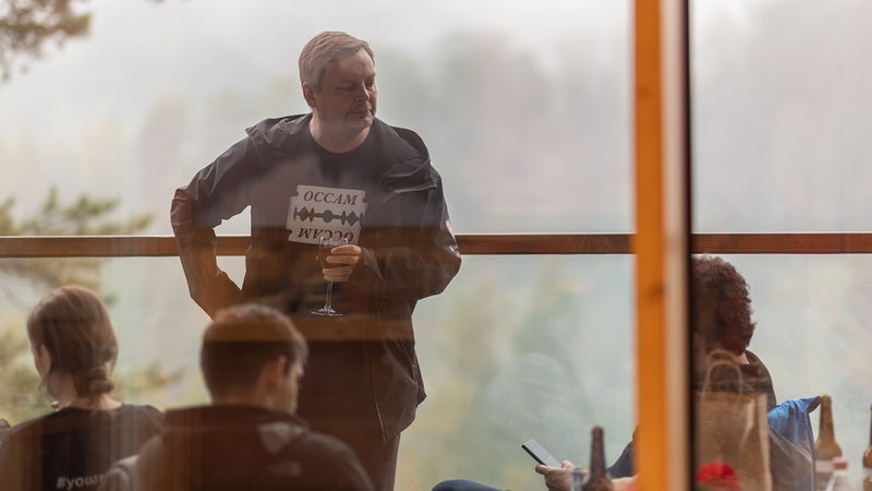 En man vars tröja hyllar ”Ockhams rakblad” deltar vid den gemensamma middagen. Foto: Karo Holmberg.