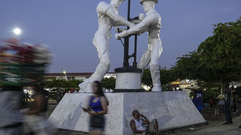 En troende vilar mot ett monument över oljearbetare under en procession för Cabimas skyddshelgon i delstaten Zulia i Venezuela, onsdagen den 27 december 2023. Foto: Matias Delacroix/AP/TT.