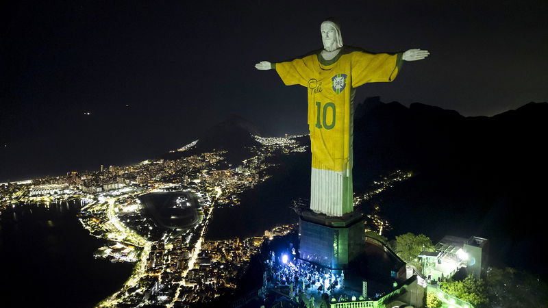 Statyn Kristus Frälsaren i Rio de Janeiro lyses upp med en bild av Pelés brasilianska tröja. Foto: Bruna Prado/AP/TT.
