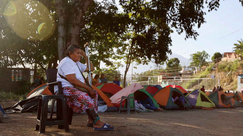 En kvinna vilar intill de tält som satts upp av anhöriga till politiska fångar, medan de väntar på besked utanför fängelset El Rodeo I i Guatire i delstaten Miranda 
i Venezuela, den 25 februari 2026. Foto: Pedro Mattey/AFP.