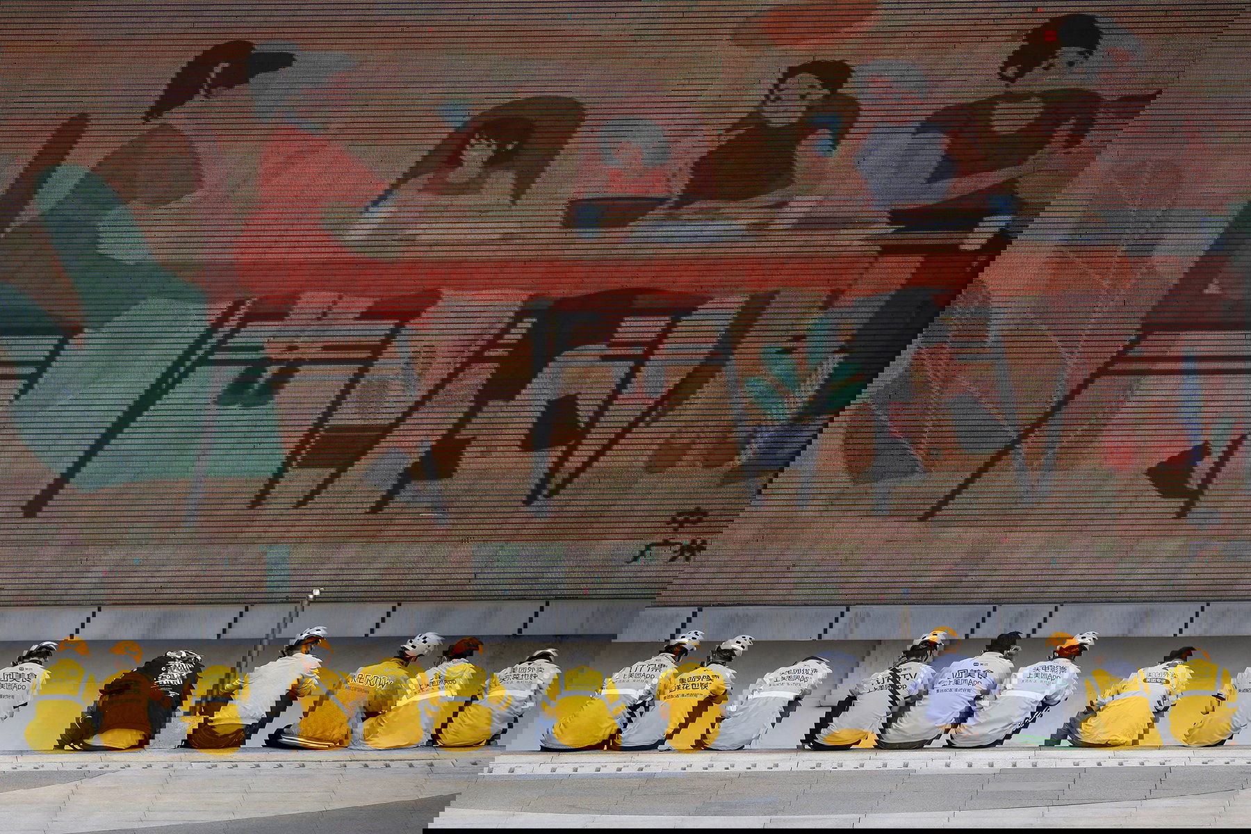 Matbud från Meituan väntar på uppdrag i Guangzhou. Plattformen har över 320 miljoner användare och miljontals anslutna handlare – samtidigt som 11–12 miljoner budförare konkurrerar om leveranser i Kina. Foto: Lin Weibin/Color China/AP/TT.