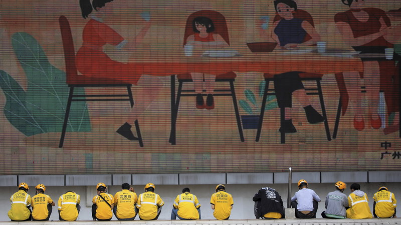 Matbud från Meituan väntar på uppdrag i Guangzhou. Plattformen har över 320 miljoner användare och miljontals anslutna handlare – samtidigt som 11–12 miljoner budförare konkurrerar om leveranser i Kina. Foto: Lin Weibin/Color China/AP/TT.